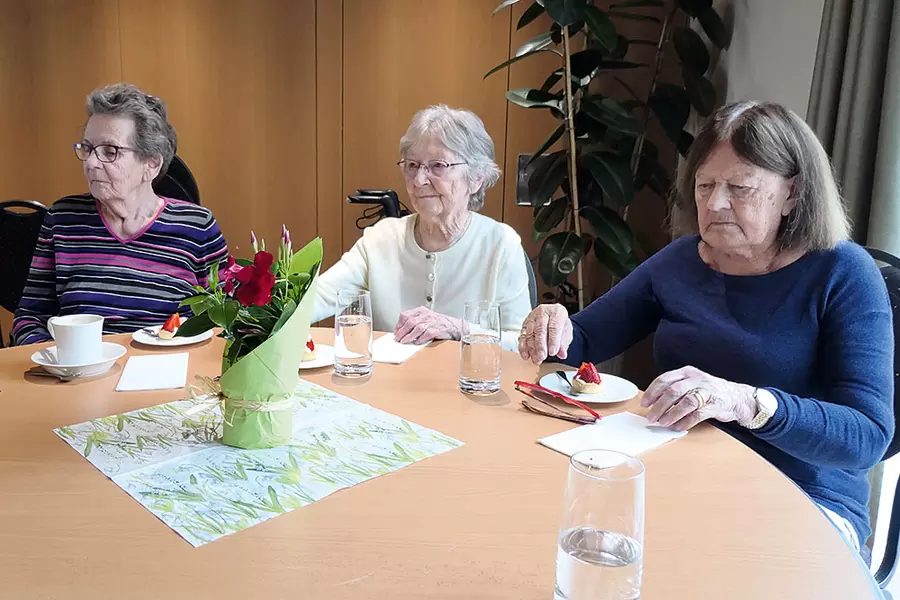 Die frisch fabrizierten Erdbeertörtchen werden von den Bewohnerinnen (v. l. n. r.) Bethli Schelbert, Ingeborg Meyer und Paula Schibig subito vertilgt, während sie gleichzeitig den musikalischen Leckerbissen des Ländler-Trios mit Erwin Gisler, Res Ulrich und Toni Bürgler lauschen.