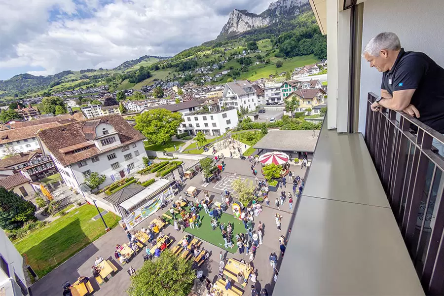 Lukas Gisler, Leiter Geschäftsbereich Alterszentrum Acherhof, schaut sich aus der 5. Etage des Alterszentrums das rege Festtreiben auf der Acherhof-Piazza an.