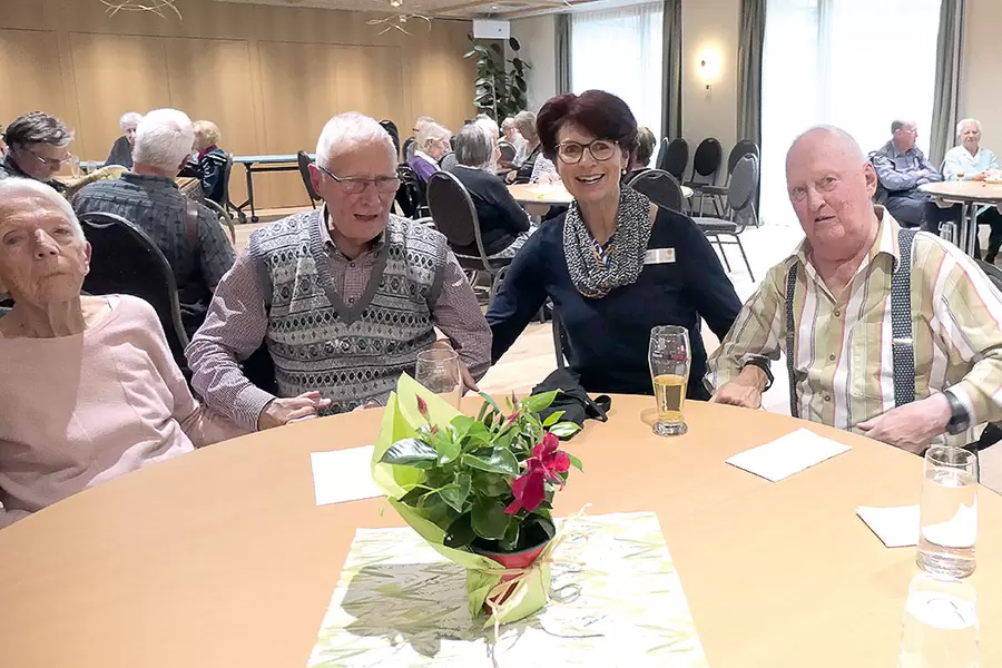 Die Bewohnenden Karolina (l.) und Paul (2. v. l.) Bürgler sowie Hans Amgwerd (r.) schunkeln mit Maria Pürro, Leitung Hauswirtschaft, zu lüpfiger Ländlermusik.