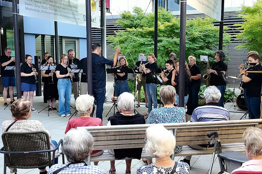 Die Feldmusik Schwyz spielt auf dem Plätzli vor dem Haupteingang zum Alterszentrum Acherhof.