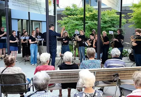 Die Feldmusik Schwyz spielt auf dem Plätzli vor dem Haupteingang zum Alterszentrum Acherhof.