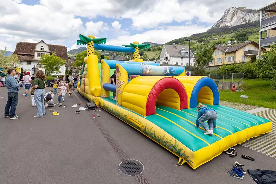 Noch einmal! – Auf der riesigen Hüpfanlage spielen unermüdlich zahlreiche Kinder. 