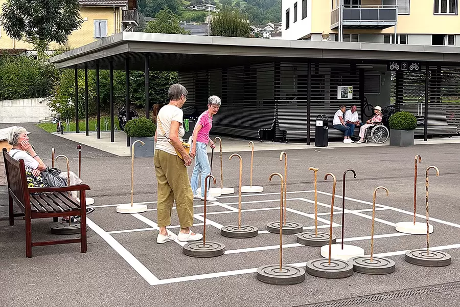 Mühlestein mit Zuschauerbank auf der Acherhof-Piazza.