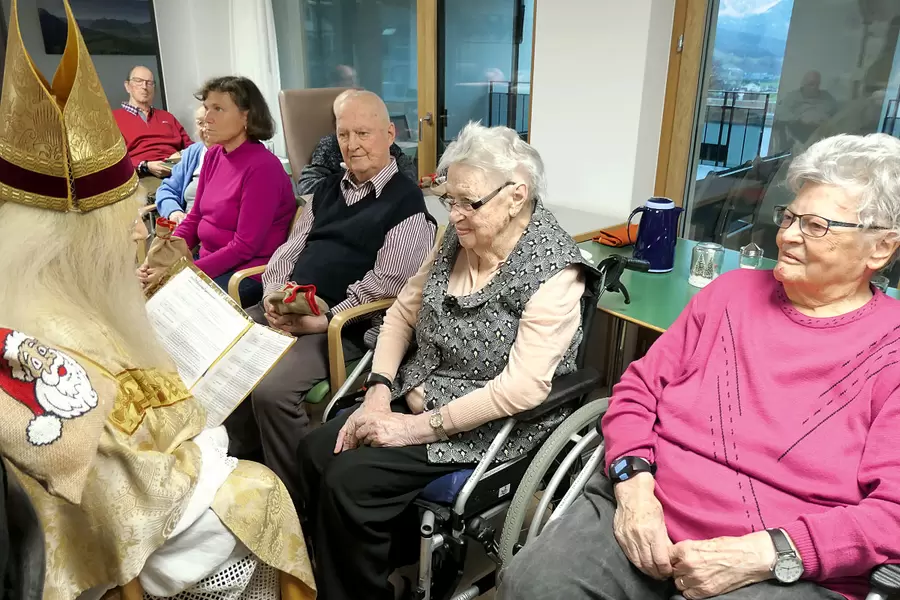 Sieht aus wie ein Sünder(innen)bänkli, ist es aber nicht: Die Bewohnenden (v. r. n. l.) Charlotte Reichmuth, Margrit Reichmuth, Hans Amgwerd und Paula Marty hören dem Samichlaus nur sehr, sehr andächtig zu.