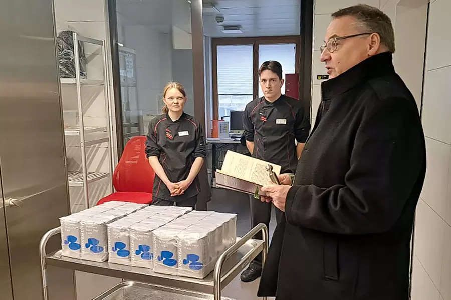 Einige Wochen vor dem Agatha-Tag segnet Pfarrer Kurt Vogt im Beisein der beiden Koch-Lernenden das Mehl in der Küche des Acherhofs.