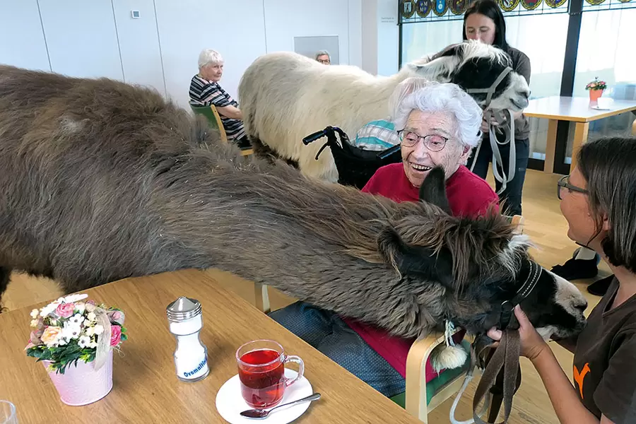 Bewohnerin Gertrud Eichhorn kuschelt mit dem Langhals.