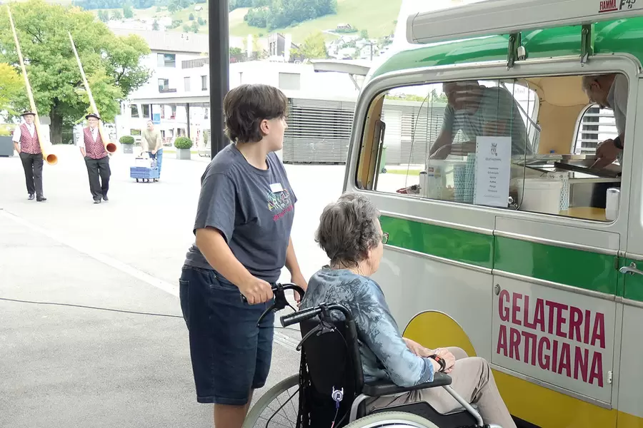 Annika Heinzer, Mitarbeiterin Aktivierung, und Bewohnerin Bethli Schelbert  suchen ein Glace aus, während das Alphornduo schon im Anmarsch ist.