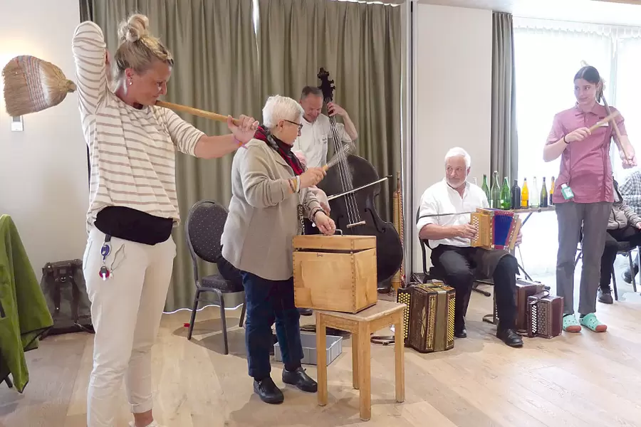 Acherhof-Mitarbeitende und -Bewohnende musizieren gemeinsam mit der Huusmusig Bürgler.