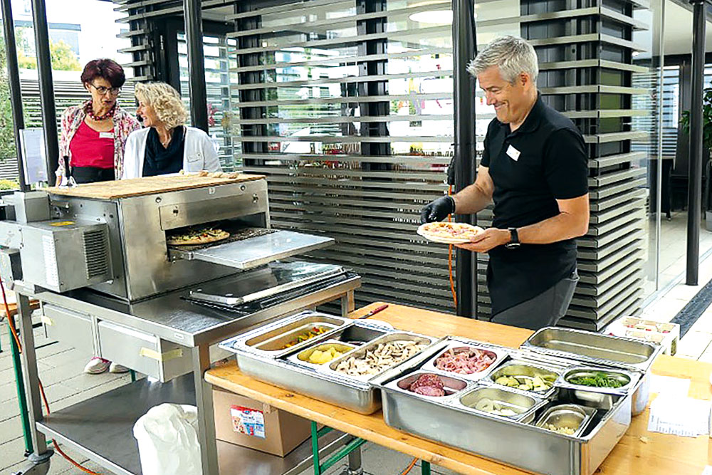 Lukas Gisler, Leiter Geschäftsbereich Alterszentrum Acherhof, Heidi Nideröst (l.), Leitung Pflege und Betreuung, und Maria Pürro, Leitung Hauswirtschaft, bewähren sich als kreative Pizzabäcker/-innen.